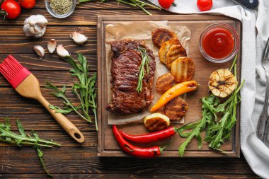 Lezzetli ızgara et, sebze ve otlar ahşap masa üzerinde kurulu