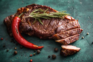 Biber biber, baharatlar ve otlar yeşil masada kesme lezzetli ızgara et