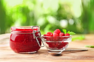 Lezzetli ahududu ile cam kavanoz reçel arka plan bulanık karşı masada