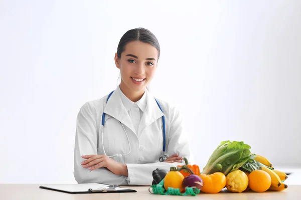 Vrouwelijke Voedingsdeskundige Zittend Aan Tafel Met Klembord Gezonde Producten Witte — Stockfoto