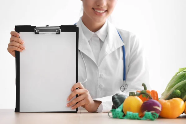 Vrouwelijke Voedingsdeskundige Zittend Aan Tafel Met Een Blanco Vel Papier — Stockfoto