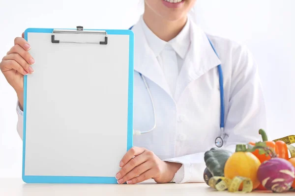 Vrouwelijke Voedingsdeskundige Zittend Aan Tafel Met Een Blanco Vel Papier — Stockfoto