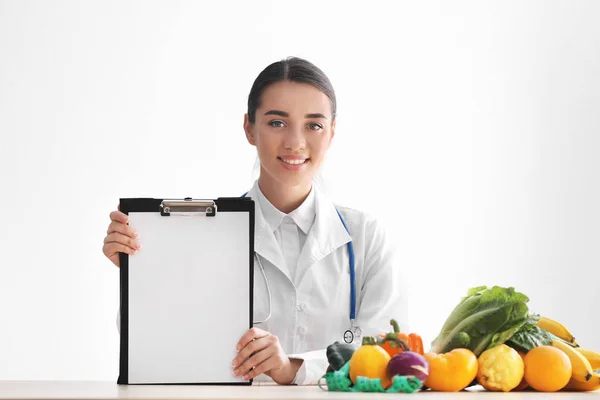 Nutricionista Feminina Sentada Mesa Com Folha Papel Branco Sobre Fundo — Fotografia de Stock