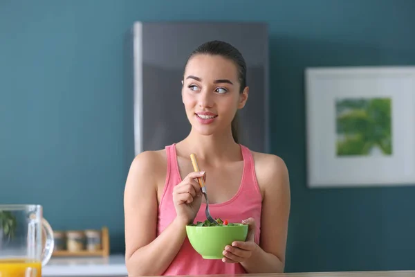 キッチンで野菜のヘルシー サラダを食べる若い女性 — ストック写真