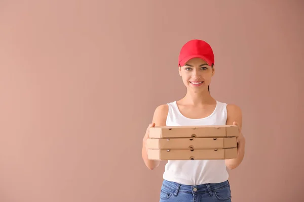 Young woman with pizza boxes on color background. Food delivery service