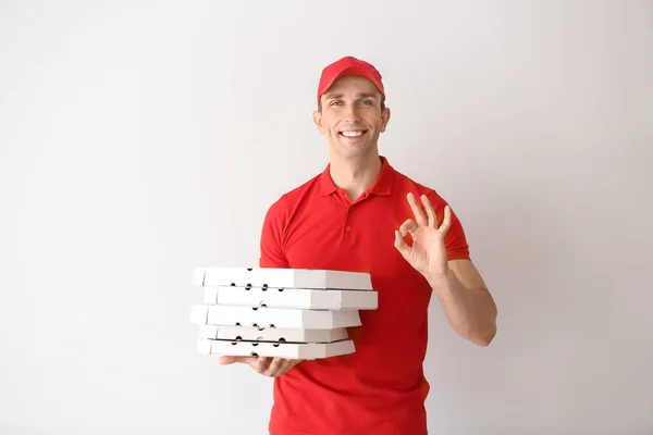 Young Man Pizza Boxes Showing Sign Light Background Food Delivery — Stock Photo, Image