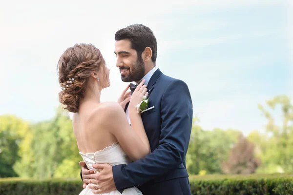 Felice Giovane Sposa Fissaggio Papillon Del Suo Sposo All Aperto — Foto Stock