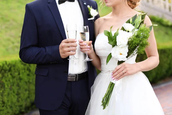 屋外にシャンパンのグラスで幸せな結婚式のカップル — ストック写真
