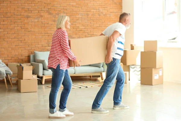 Mature Couple Carrying Box Indoors Moving New House — Stock Photo, Image