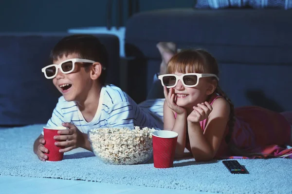 眼镜可爱的孩子晚上看电影在地毯上 — 图库照片