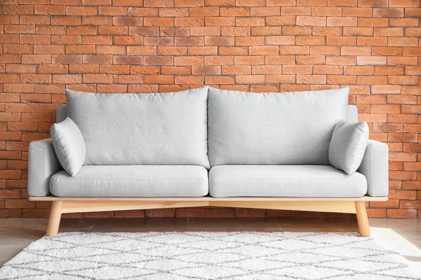 Komfortowa Sofa Pobliżu Mur Cegły — Zdjęcie stockowe