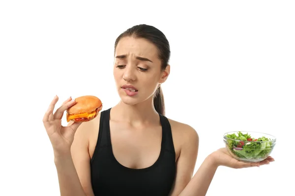 Mujer Joven Eligiendo Entre Ensalada Verduras Frescas Hamburguesa Sobre Fondo — Foto de Stock