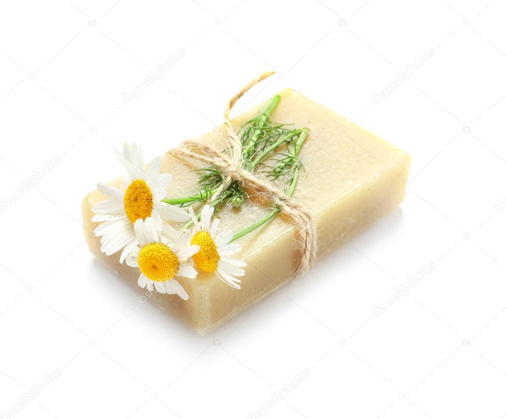 Natural soap with chamomile flowers on white background