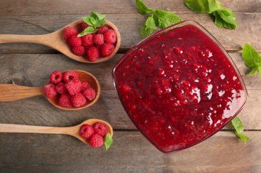 Kaşık çilek ve kase lezzetli ahududu reçeli ahşap tablo