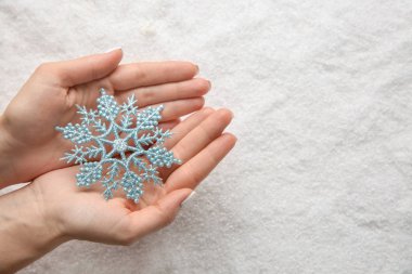 Kar tanesi karlı arka planda tutan kadın