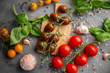 Gri arka plan üzerinde farklı çeşit taze kiraz domates ile kompozisyon