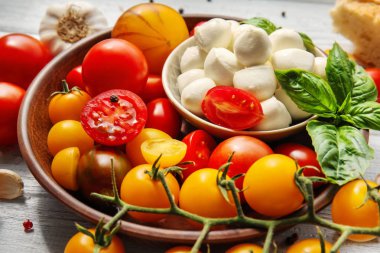 Mozzarella peyniri ve plaka, closeup üzerinde taze kiraz domates ile kase