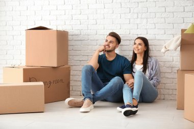 Hareketli kutular yeni giriş katında oturan ile genç mutlu çift