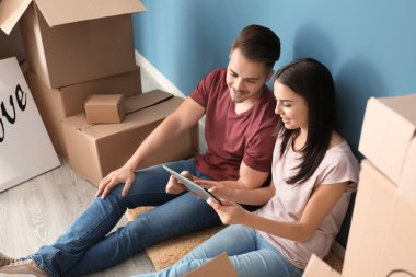 Tablet Pc ve yeni giriş katında oturan hareket kutuları ile genç mutlu çift