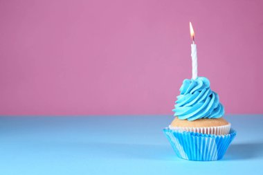 Renk arka plan üzerinde mum yanan ile lezzetli Doğum günü kek