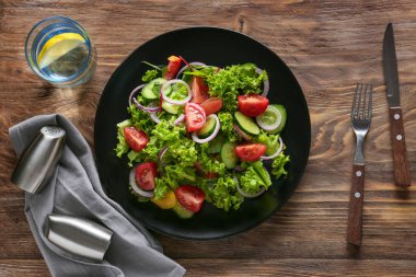 Ahşap masa üzerinde lezzetli sebze salatası ile plaka