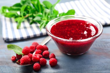 Ahşap masa üzerinde lezzetli frambuaz reçeli ile kase