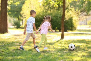 Sevimli küçük çocuklar açık havada futbol oynarken