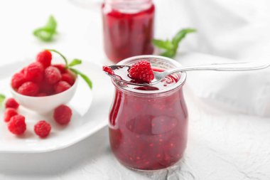 Işık tablosu üzerinde lezzetli frambuaz reçeli ile jar