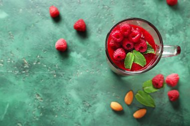 Cam bardak ile lezzetli ahududu güler yüzlü renk arka plan üzerinde