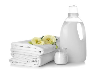Stack of clean bed sheets and washing detergents on white background clipart