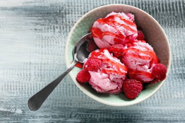 Lezzetli ahududu-dondurma ile ahşap masa üzerinde kase