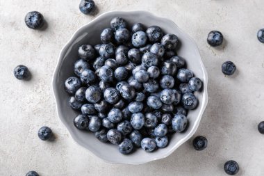 Işık tablosu üzerinde olgunlaşmış yaban mersini ile kase