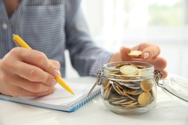 Kadın masada, closeup sikke sayma. Tasarruf kavramı