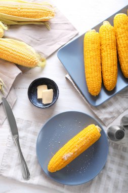 Ahşap masa üzerinde haşlanmış corncobs ile kompozisyon