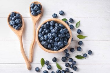 Kase ve ahşap masa üzerinde olgunlaşmış yaban mersini ile kaşık