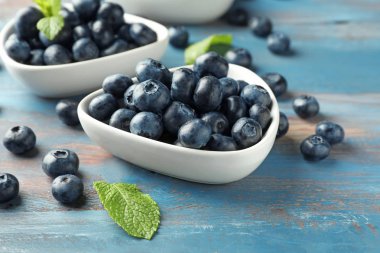 Ahşap masa üzerinde olgunlaşmış yaban mersini ile kase