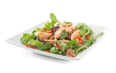 Tabak beyaz zemin üzerine deniz ürünleri ile lezzetli sebze salatası