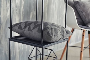 Gri duvar kapalı yakınındaki yumuşak yastık ile stand