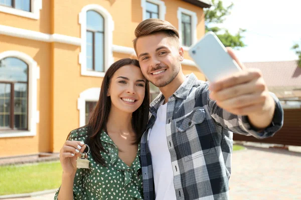 Junges Glückliches Paar Macht Selfie Mit Schlüssel Seines Neuen Hauses — Stockfoto