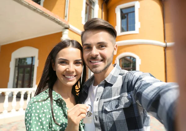 Junges Glückliches Paar Macht Selfie Mit Schlüssel Seines Neuen Hauses — Stockfoto