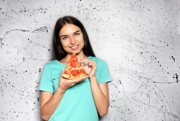 Młoda Kobieta Jedzenie Kromka Pyszną Pizzę Szarym Tle — Zdjęcie stockowe