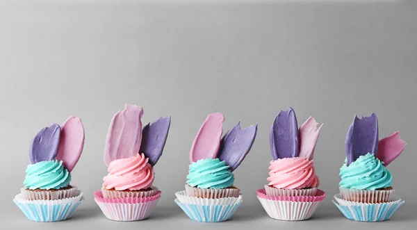 Creative birthday cupcakes on color background