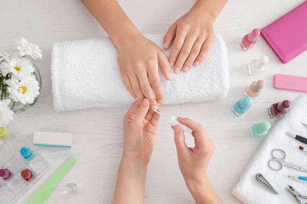 Young woman getting professional manicure in beauty salon, top view