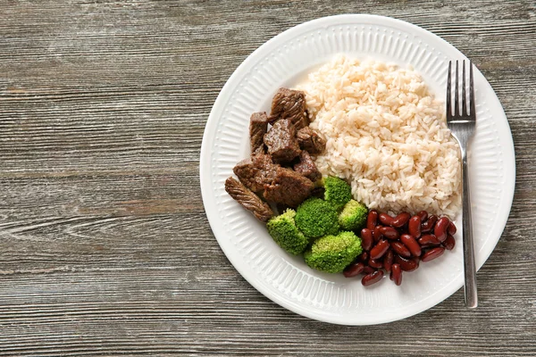 Tasty boiled rice with meat and vegetables on plate