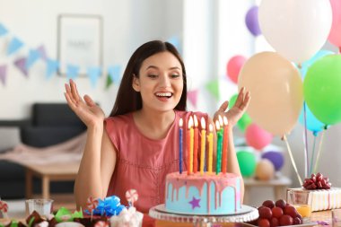 Güzel genç kadın Doğum günü pastası ile masada