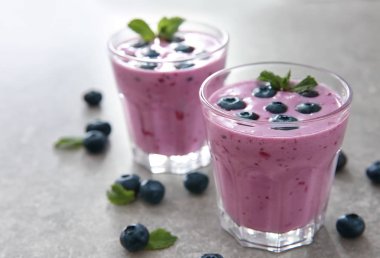 Lezzetli blueberry smoothie masa lambası üzerinde bardak