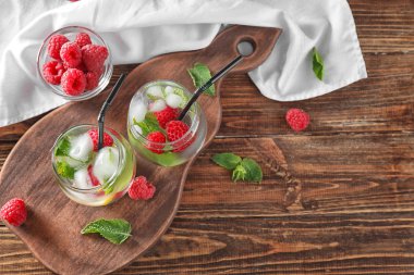 Ahşap masa üzerinde taze ahududu mojito bardak