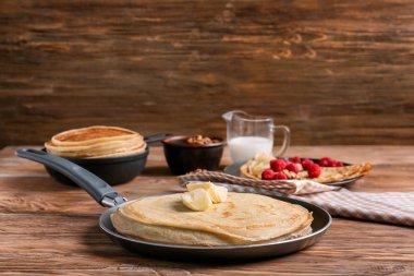 Ahşap masa üzerinde lezzetli ince krep tava