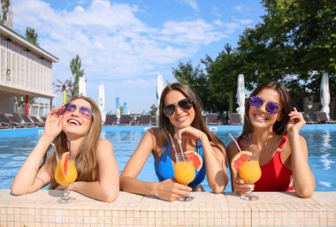 Güzel genç kadın elbiseleri yaz gününde resort adlı kokteyl içme yüzme içinde