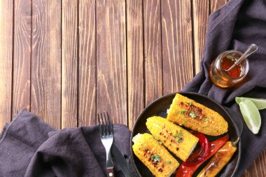 Ahşap masa üzerinde lezzetli ızgara Mısır ile plaka